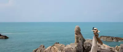 A woman walking by Tongsai Bay in Koh Samui Thailand