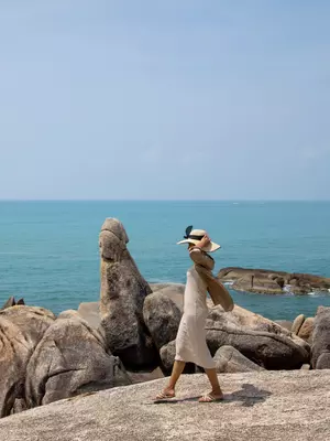 A woman walking by Tongsai Bay in Koh Samui Thailand